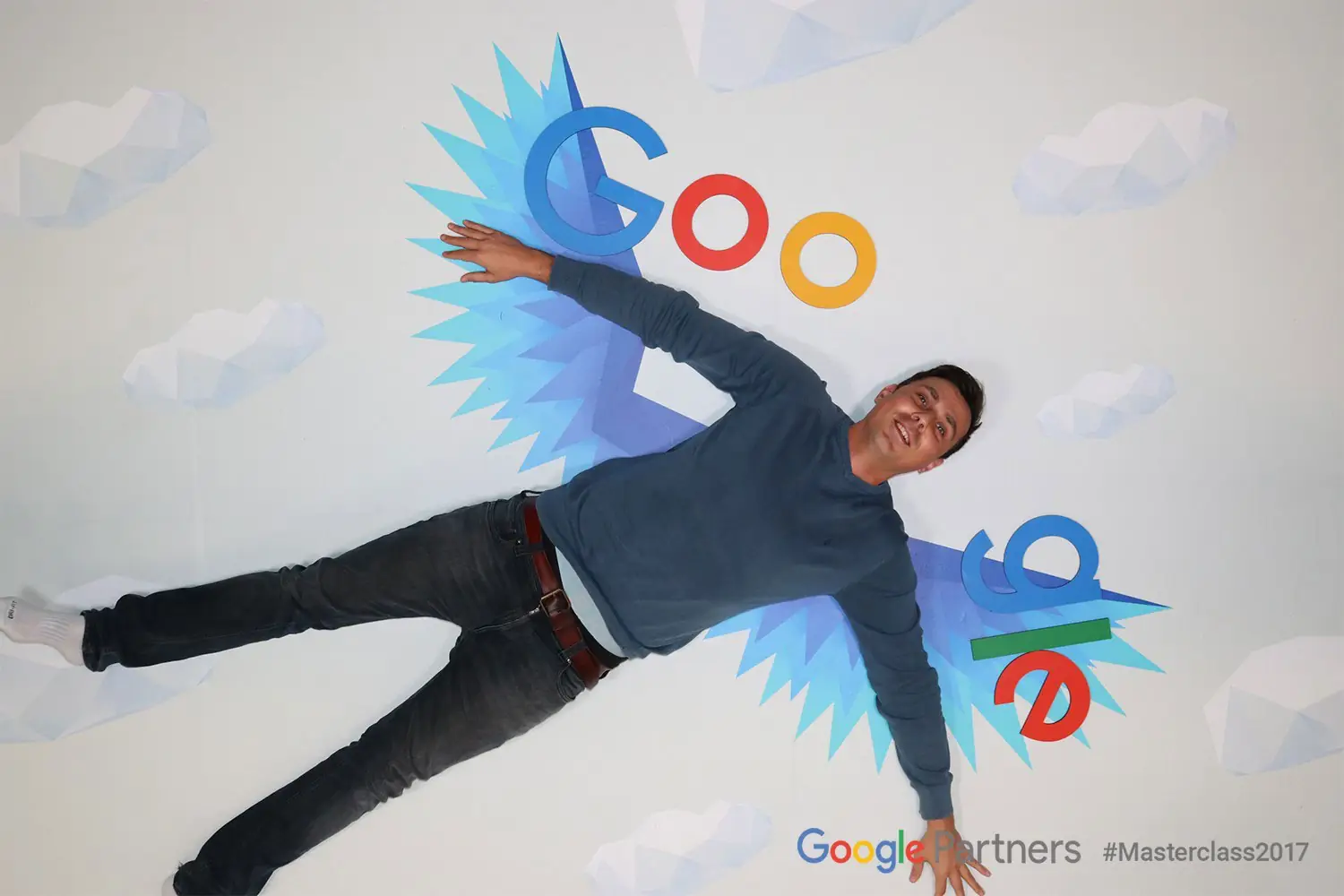 A man lying on the floor with a Google logo painted around him like wings