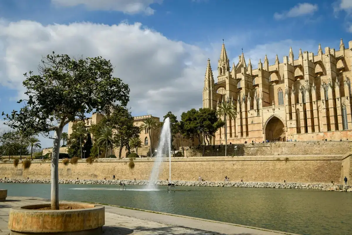 Palma Cathedral in Mallorca on a sunny day, seen across the park and the lake in front of it
