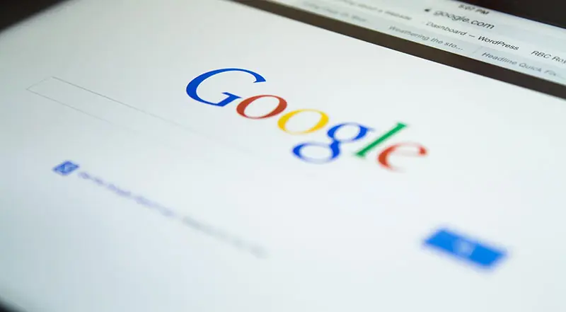 The Google search page on a laptop screen